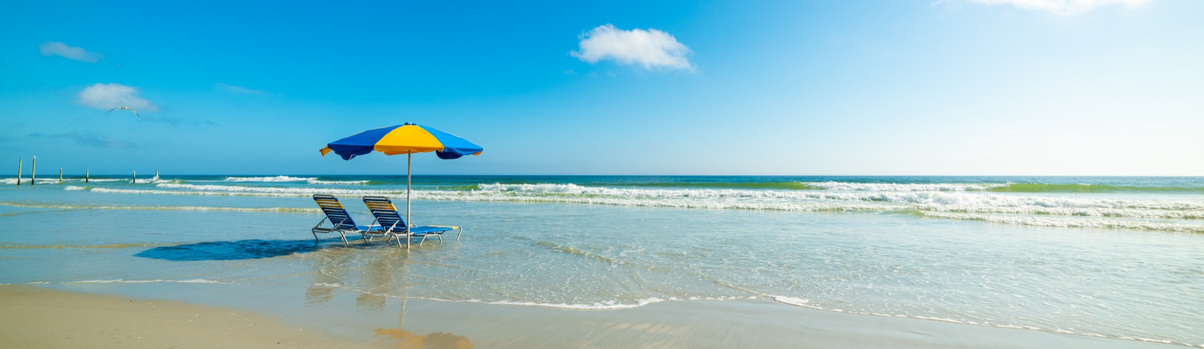 Blue beach chairs on the beach with waves